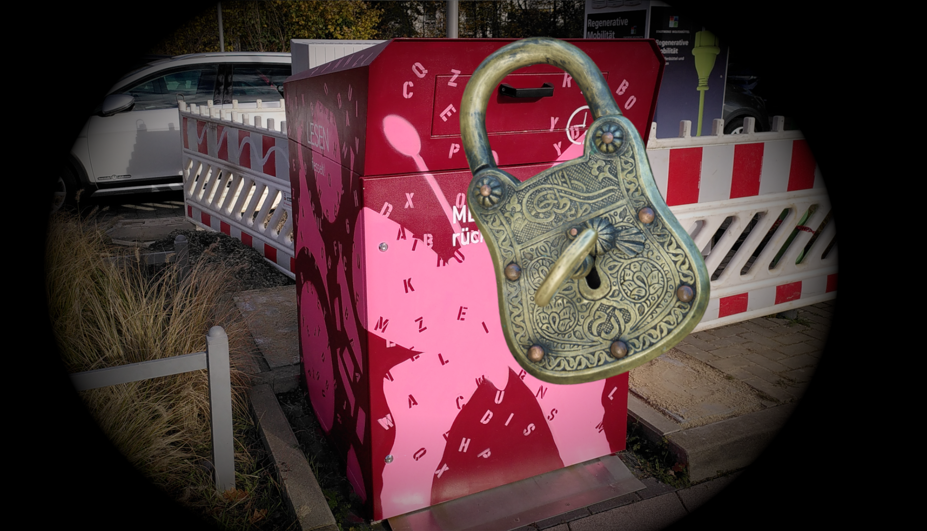 Die rot-pinke Rückgabebox am Parkplatz vor der Stadtbücherei, ein wenig vignettiert, darüber ist per Fotomontage ein antikes Vorhängeschlosse eingefügt