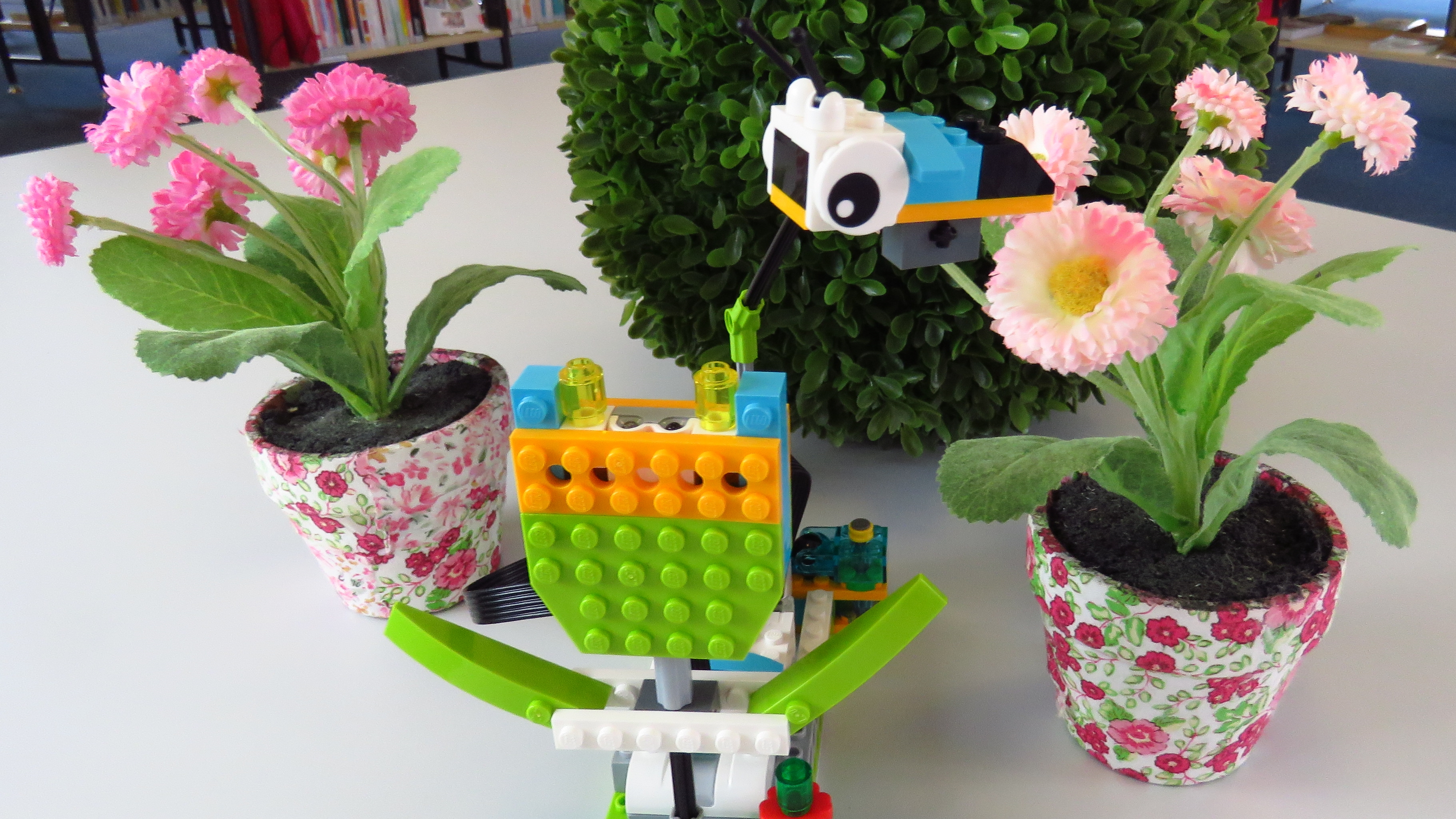 Bild eines Legomodells, eine Fliege, die motorgetrieben um eine Legoblume kreist
